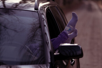 The girl stuck her legs out of the window of her black car. vacation and travel concept. unicorn socks