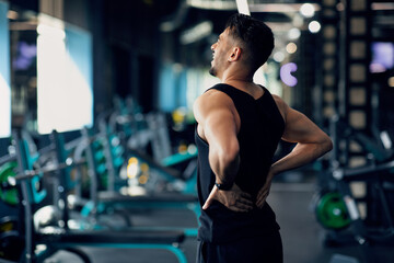 Fototapeta na wymiar Portrait Of Young Arab Bodybuilder Suffering Lower Back Pain At Gym