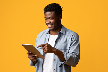 Happy black man pointing at digital tablet screen