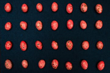 red candies rows on a blue glitter cardboard background, top view