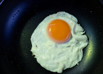 Fried or grilled egg in the pan seen up close isolated egg