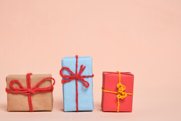 Gifts packed in multicolored paper on pastel beige background.Concept Christmas holidays and eighth March in spring.