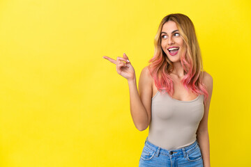 Fototapeta na wymiar Young woman over isolated yellow background intending to realizes the solution while lifting a finger up