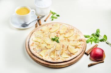 Sweet pizza with apples, cinnamon and mint on a light background