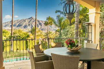 view of a dining table from a villa terrace overlooking the mountains of Marbella along the Costa...