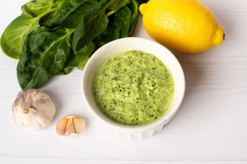 spinach sauce with lemon and garlic on a white background