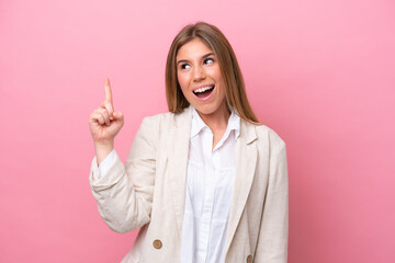 Young caucasian woman isolated on pink bakcground intending to realizes the solution while lifting a finger up