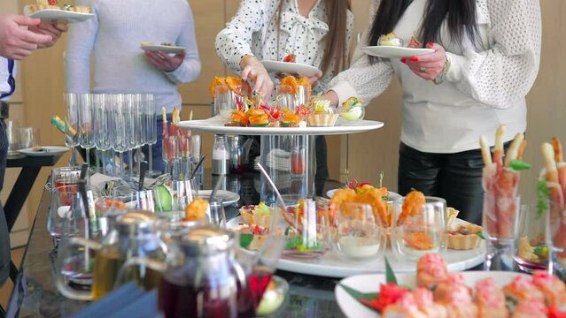 Meals for a group of people, buffet in a luxury office, close-up. The business team enjoys a break at work, are treated to canapes snacks.Business lunch.Beautifully decorated banquet table.catering