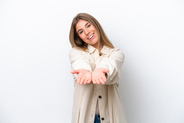 Young caucasian woman isolated on white bakcground holding copyspace imaginary on the palm to insert an ad