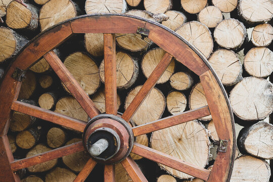 Retro wheel photo. Pieces of wood and Wagon Wheel. Old cart wheels .Vintage wooden carriage wheel,  Wood background. Old Wooden Carriage wheel hanging on the barn