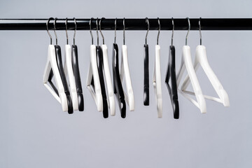 Metal rack with clothes hangers on grey background