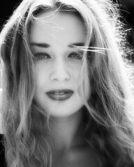 Portrait of a beautiful, healthy and attractive young woman with long blond hair and beautiful face with outdoor background. Black and white.