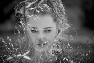Portrait of a beautiful, healthy and attractive young woman with long blond hair and beautiful face with outdoor background. Black and white.