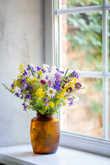 field simple flowers in a vase on the window, summer day, cozy house