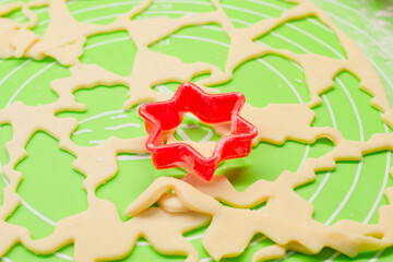 Making cookies with cookie cutters on a silicone mat. Red star shape close-up selective focus