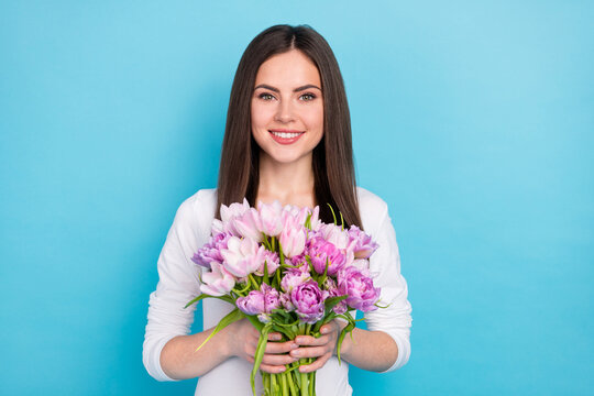 Photo of adorable charming good mood woman receive butch of flowers on her birthday isolated on blue color background