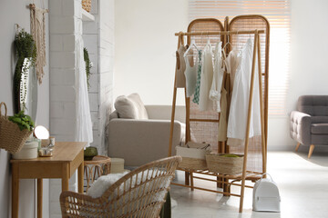 Fototapeta na wymiar Rack with stylish women's clothes and dressing table in room. Interior design