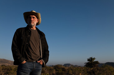 Adult man in cowboy hat on Tabernas desert during sunset. Almeria, Spain