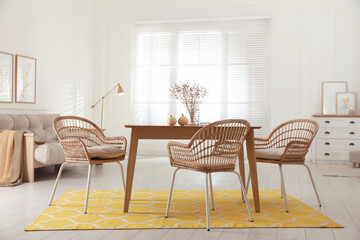 Dining room interior with wooden table and wicker chairs