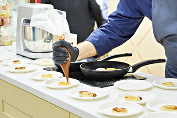 The cook prepares cheesecakes syrniki in frying pan