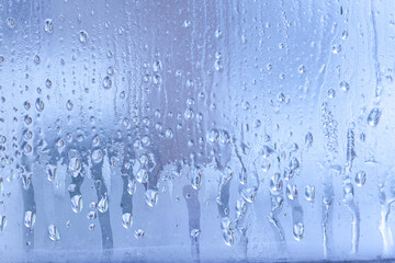 Naklejka na ściany i meble Condensation on the clear glass window. Water drops. Rain. Abstract background texture. Outside the window, bad weather, rain