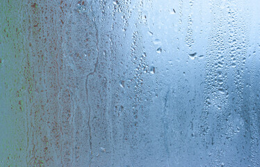 Background water drops on the glass, wet window glass with splashes and drops of water and lime, texture autumn background. Condensation on the glass