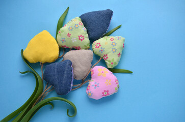 a bouquet of multi-colored hearts sewn from handmade fabric for a holiday postcard