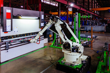 Robotic arm working with metal sheet at hydraulic bending machine