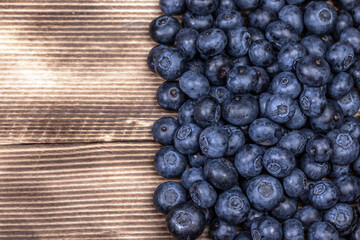 Blueberry background. Ripe blueberry on wooden background.