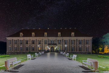 Pałac książęcy w mieście Żagań w Polsce w nocnej scenerii. Czyste, bezchmurne niebo rozświetlone jest gwiazdami.
