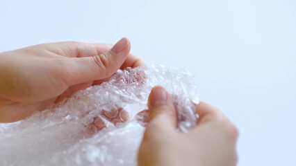 Fototapeta premium ASMR, woman presses plastic bubble wrap as a stress relief. Popping bubble wrap