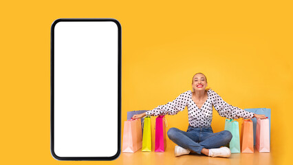 Woman Sitting Near Big Smartphone And Shopping Bags, Yellow Background