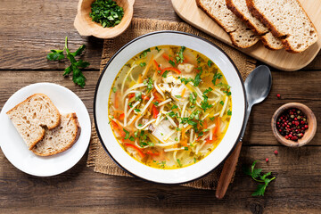 Traditional Moldavian chicken soup with homemade pasta. Wooden rustic table. top view