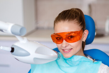 Teeth whitening for woman. Bleaching of the teeth at dentist clinic.