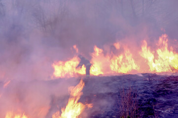 Strażak gaszący pożar. Konwekcja rozgrzanego powietrza i dymu rozmywa widok.