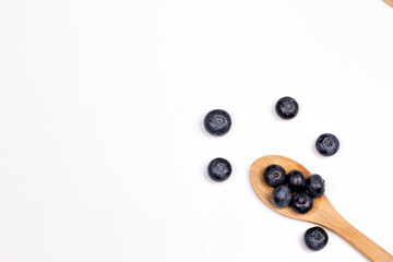 Wooden spoon with berries on white background.