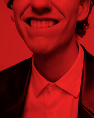 The charming smile of an incredible charismatic guy.using the red filter.dressed in a black jacket
