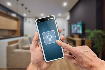 Male hands holding smartphone to control lightning in room