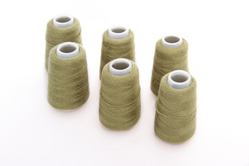 Green spool of thread isolated on white background. Skein of woolen threads. Yarn for knitting. Materials for sewing machine. Coil