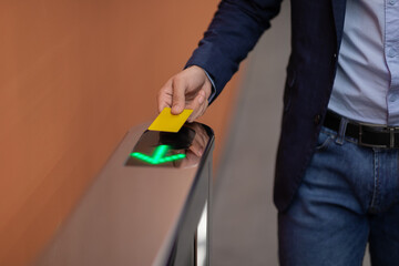 Unrecognizable man holding electronic entrance gate card, closeup