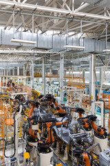 Vertical photo of automobile production line. Modern car assembly plant. Auto industry. Interior of...