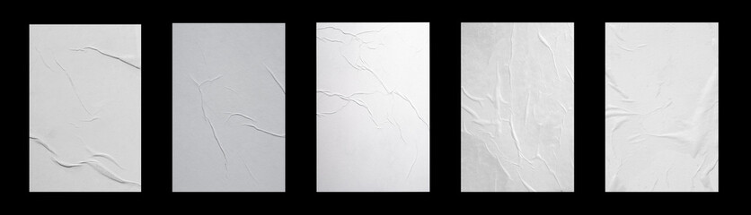 Five white sheets with folds isolated on a black background.