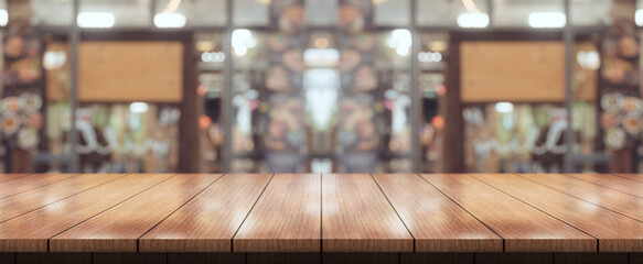 Empty wooden table top with lights bokeh on blur restaurant background.
