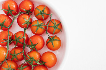 Bouquet of fresh ripe cherry tomatoes ready to eat on a bright white background