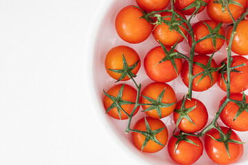 Bouquet of fresh ripe cherry tomatoes ready to eat on a bright white background