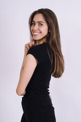 Young Female model in studio. high fashion portrait of young elegant woman. skinny black pants, black heels shoes. 