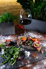 fresh crusty sandwich with roast beef, vegetables, tomato, cucumber and wine