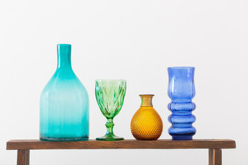 glass vases on wooden shelf on white background