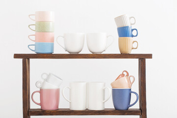 colorful cups on  wooden shelf on  white background
