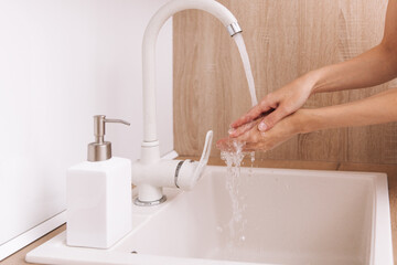 Washing hands under the flowing water tap. Washing hands rubbing with soap for corona virus prevention, hygiene to stop spreading corona virus in or public wash room. Hygiene concept hand detail